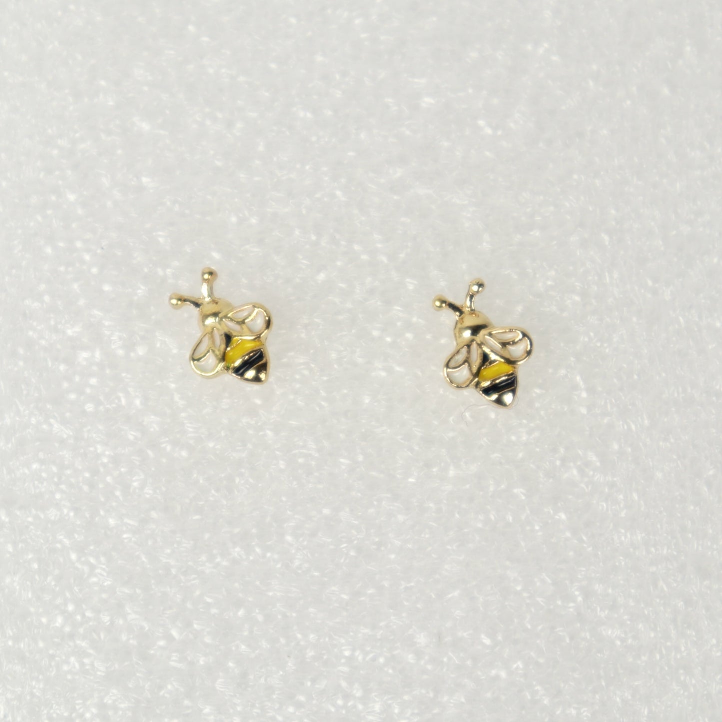 Gold bee-shaped earrings on a white background