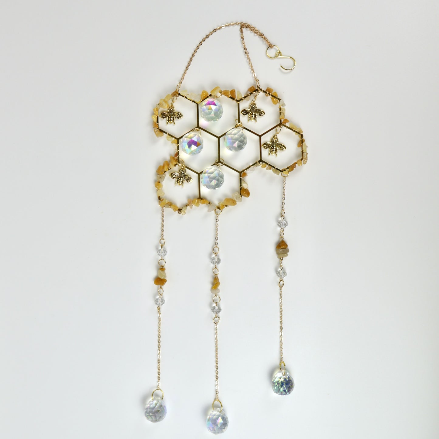 Decorative honeycomb with bees and crystal-like beads on a white background