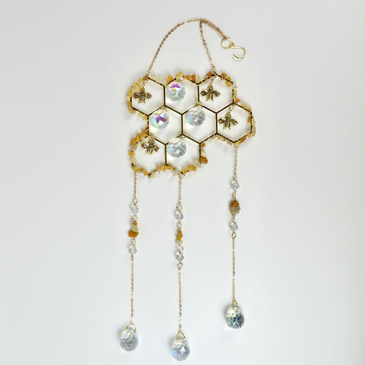 Decorative honeycomb with bees and crystal-like beads on a white background