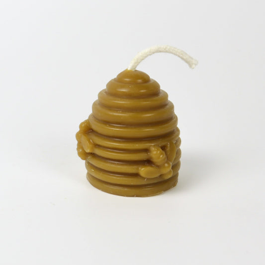 Beeswax candle shaped like a beehive on a white background